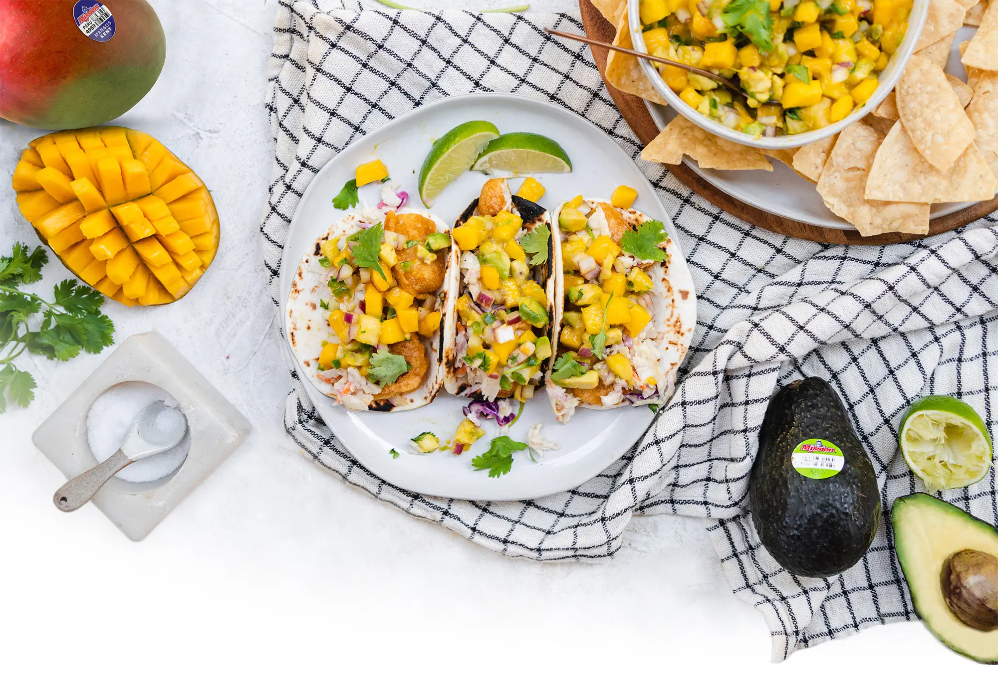 overhead photo of seafood tacos with avocados and mangos