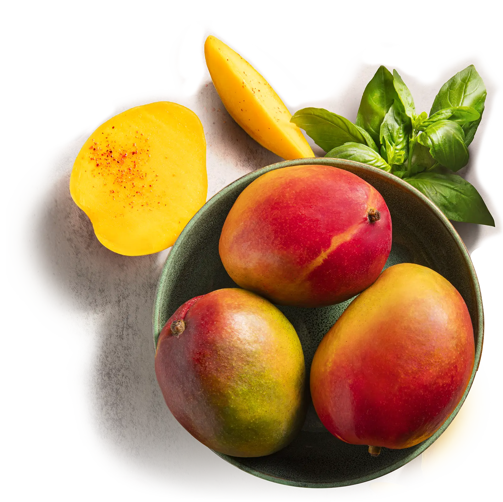 bowl of mangos and sliced mangos on a countertop