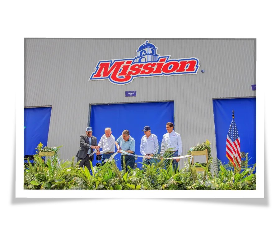 Exterior photo of the Mission Guatemalan packing house building with 5 men standing in front cutting a ribbon